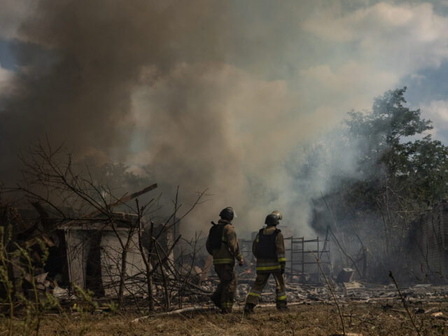 KRAMATORSK, UKRAINE - SEPTEMBER 8: Firefighters walk in front of fire at residential distr