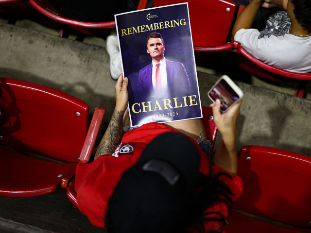An attendee holds a flyer during a vigil in memory of right-wing activist Charlie Kirk at