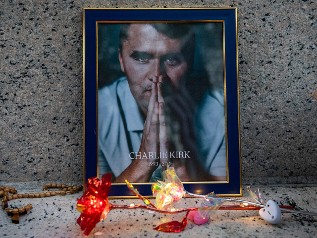 GettyImages-2235613236 The reflection of a US flag appears in a portrait of Charlie Kirk during a vigil in his ho