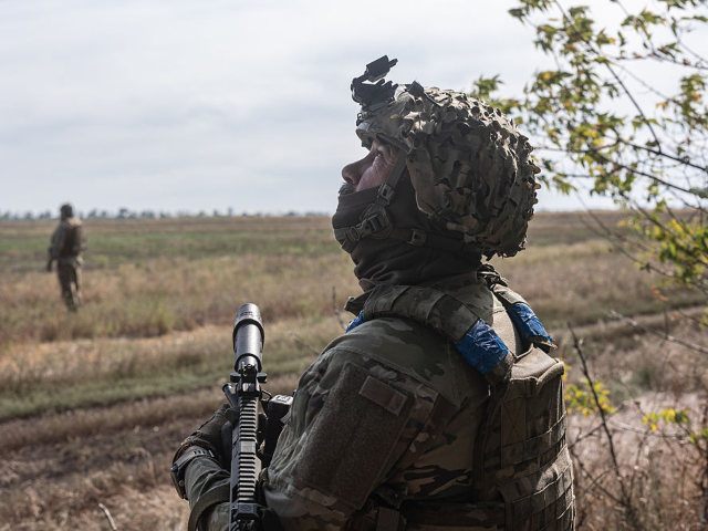 DONETSK OBLAST, UKRAINE - SEPTEMBER 16: Ukrainian soldier looks up at the sky from his com