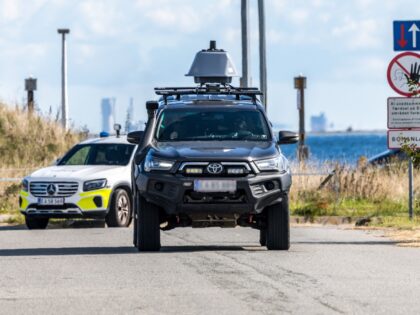 Police cars are seen close to Copenhagen Airport on September 23, 2025. Large drones that