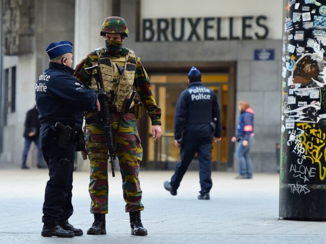 TOPSHOT - A Belgian soldier speaks to a police officer outside Brussels Central Station as