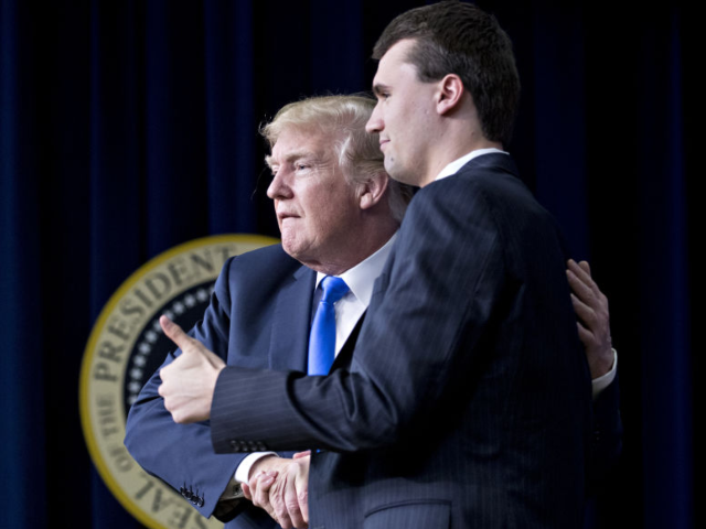 U.S. President Donald Trump, left, shakes hands with moderator Charlie Kirk after a discus