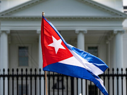 A demonstrator holds up the Cuban flag while protesting in front of the White House in Was