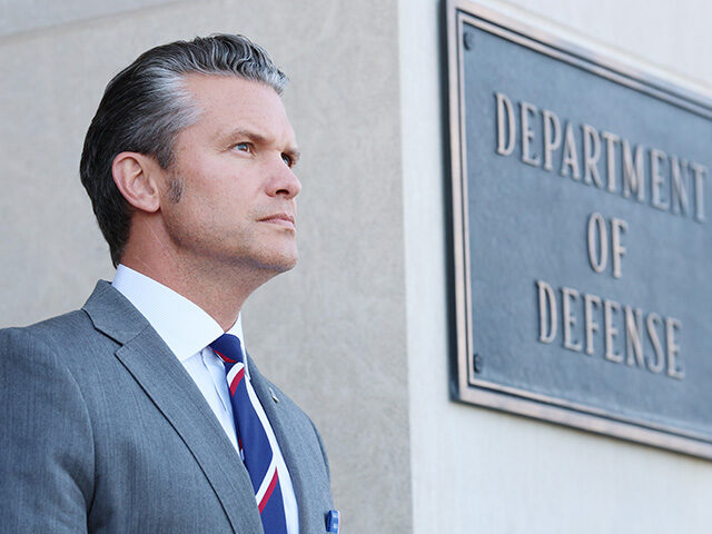 U.S. Secretary of War Pete Hegseth stands at attention during an advanced honor cordon for