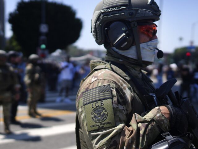 An ICE Special Response Team member stands guard outside the Metropolitan Detention Center