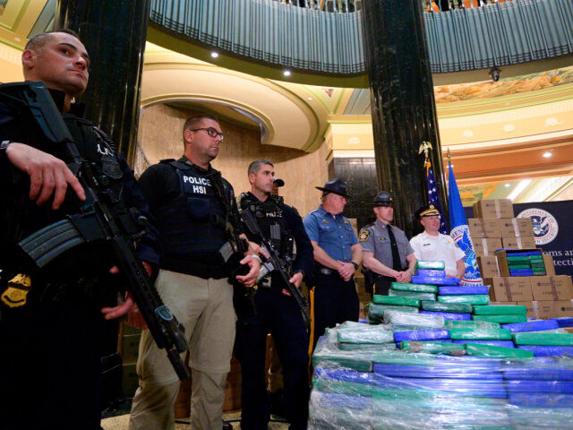 Large Drug Bust Heavily armed officers stand guard as law enforcement officials present a part of the evid