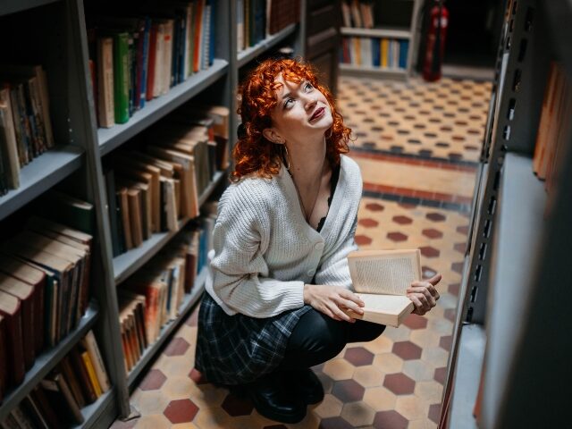 Librarian searches the stacks for a book