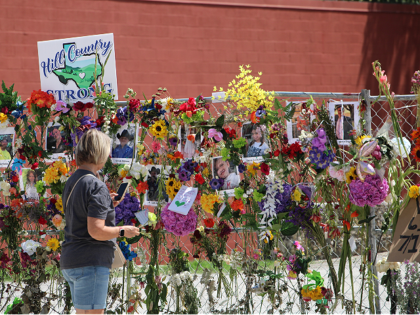 Mourner looks at photos on memorial (3) (Randy Clark/Breitbart Texas)
