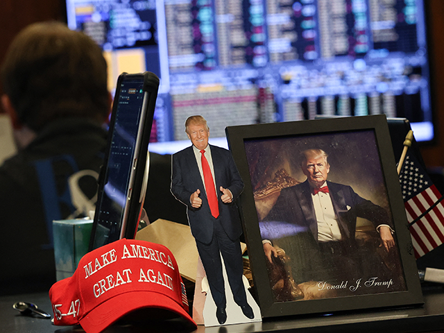 Images of President Donald Trump sit on a desk as traders work on the floor of the New Yor