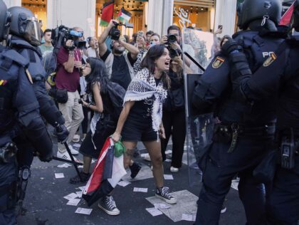 A protester argues with police as they try to disrupt the twenty-first stage of the Spanis