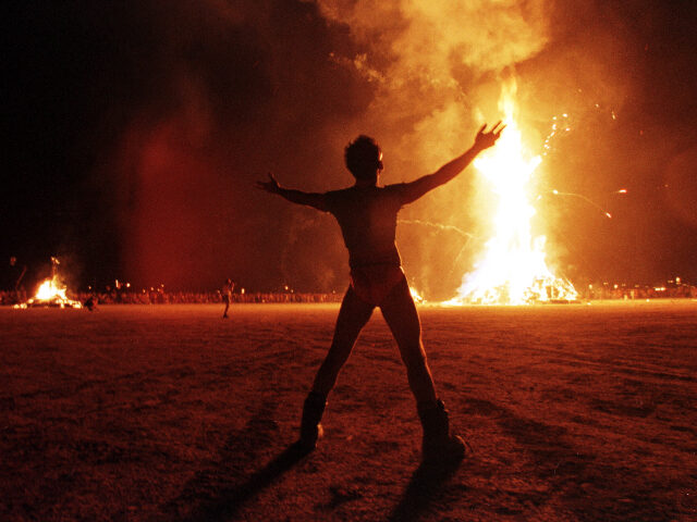 burningman BLACK ROCK DESERT, UNITED STATES: A "Burning Man" participant holds up his arms