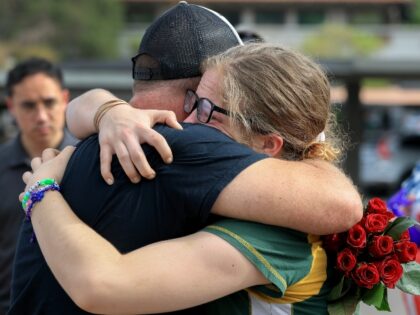 PHOENIX, ARIZONA - SEPTEMBER 17: Mark Ince hugs Avery King as they visit the makeshift mem