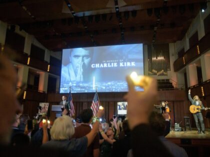 People hold candles and sing during a memorial and prayer vigil for Charlie Kirk at the Jo