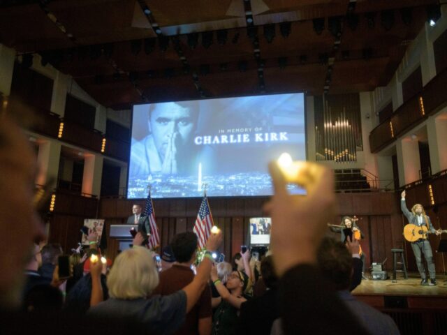 People hold candles and sing during a memorial and prayer vigil for Charlie Kirk at the Jo