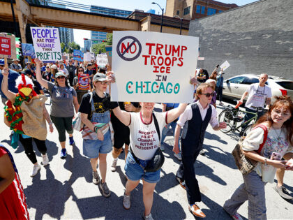 Protesters hold signs as they march during a "Workers over billionaires" rally on Labor Da
