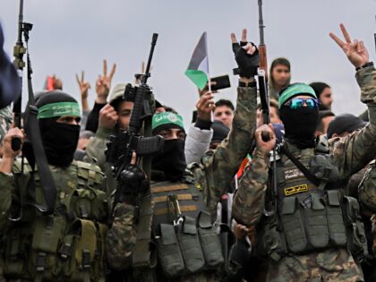 Palestinian Hamas fighters and people gather in Nuseirat in the central Gaza Strip, as pre
