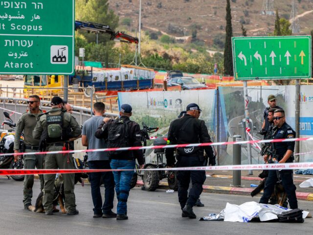 israel attack EDITORS NOTE: Graphic content / Israeli security forces gather by a body next to a bus at