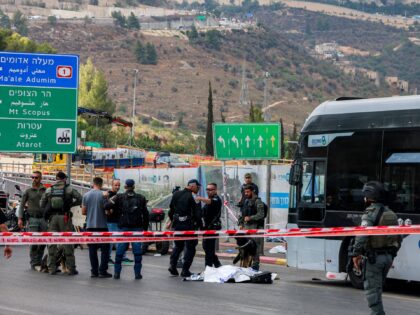 EDITORS NOTE: Graphic content / Israeli security forces gather by a body next to a bus at