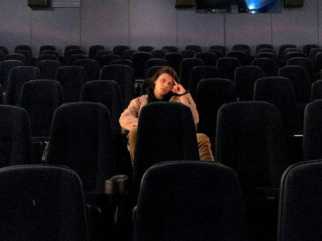 man sitting alone in a movie theater
