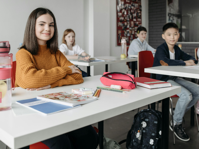 Students Sitting by Their Desks Inside the Classroom