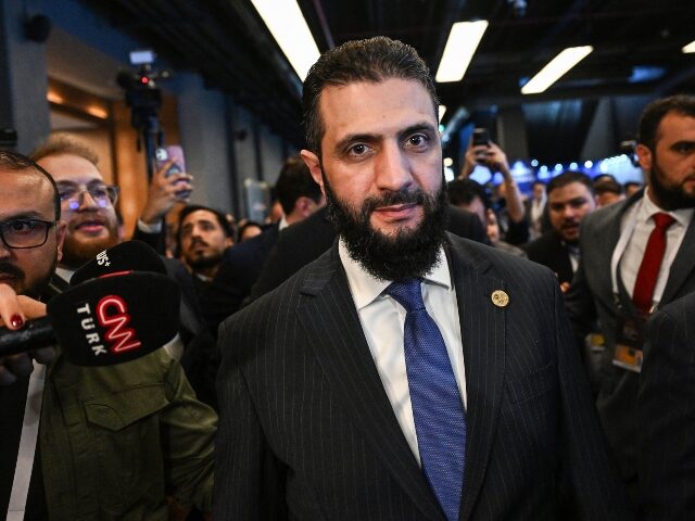 TOPSHOT - Syria's interim President Ahmed al-Sharaa (C) leaves a bilateral room after