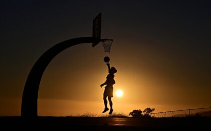 A boy shoots hoops at sunset on August 19, 2025 in San Pedro, California amid a brutal hea