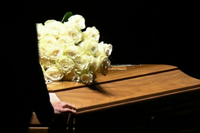 The coffin was laid in a darkened room, surrounded by white paper lanterns