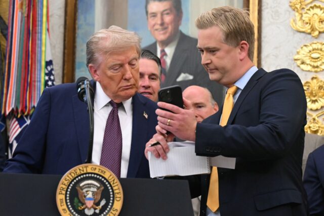 Fox News reporter Peter Doocy shows US President Donald Trump his phone during an Oval Off
