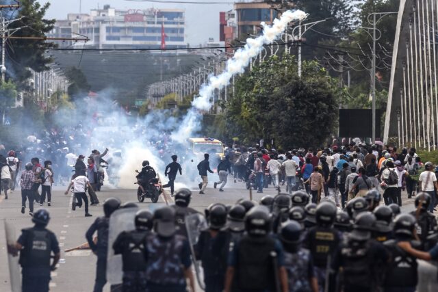 Riot police fire tear gas to disperse demonstrators during a protest outside the Parliamen