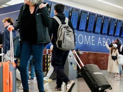 Travelers look at flight information boards at Hartsfield-Jackson Atlanta International Ai