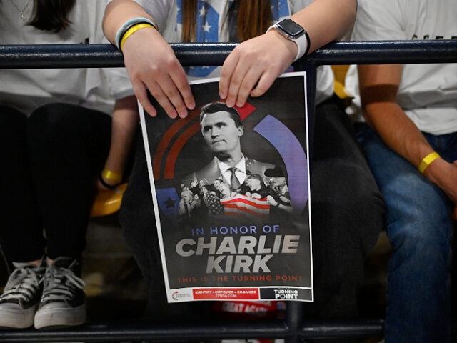 93025-poster-Charlie-Kirk-Turning-Point-USA-rally-ap An attendee holds a poster of Charlie Kirk at a Turning Point USA rally at Utah State Univ
