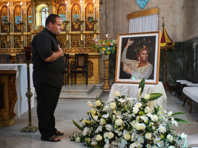 AP25294684803063 A man stands before a framed image of late singer Celia Cruz after attending a memorial Ma
