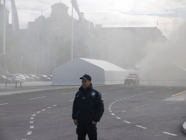 Serbia Fire A policeman stands guard as a fire is localized inside the government supporters' cam