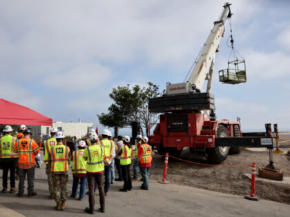 U.S. Army Corps of Engineers workers and contractors stand at a ceremony marking the final