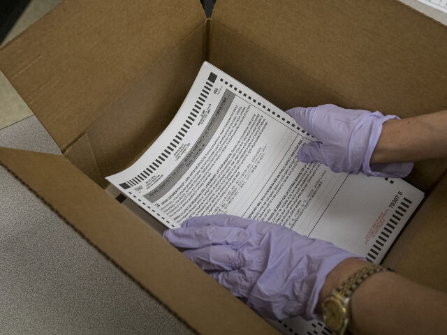 Ballots in cardboard box A worker wearing protective gloves puts ballots into a box at the Contra Costa County Cler