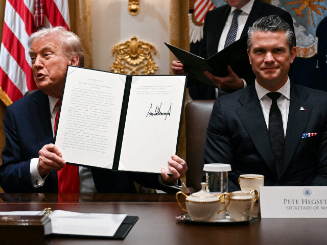 Donald Trump and Pete Hegseth at cabinet meeting US President Donald Trump (C) holds up signing documents recognizing days honoring Leif Er