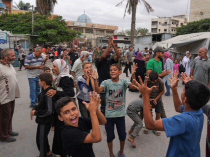 Palestinians celebrate following the announcement that Israel and Hamas have agreed to the