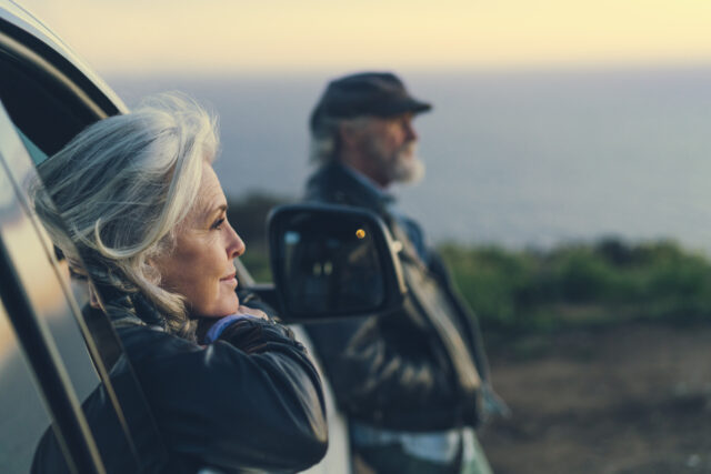 Mature woman sitting in car during sunset