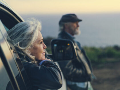Mature woman sitting in car during sunset