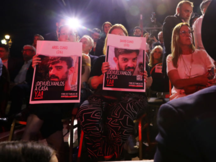 BUENOS AIRES, ARGENTINA - DECEMBER 12: Attendants hold up portraits of Hamas' hostages Ari