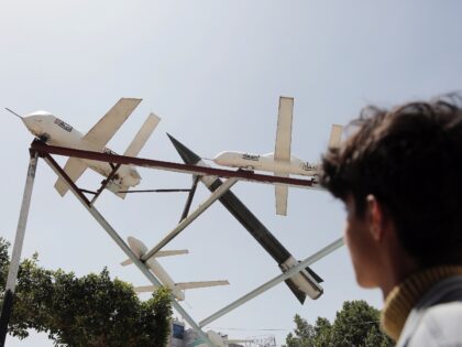 SANA'A, YEMEN - APRIL 25: Yemenis walk under mock drones and missiles displayed at a squar
