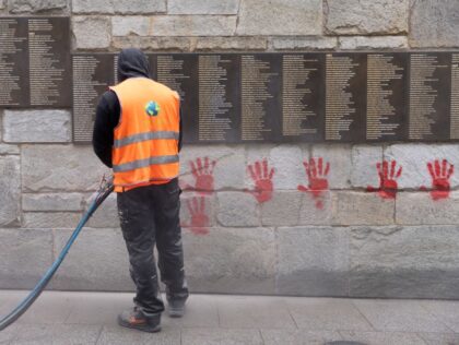 A city employee is at work to clean the "Wall of the Righteous" (Mur des Justes)