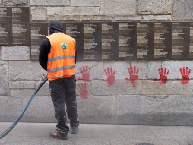 A city employee is at work to clean the "Wall of the Righteous" (Mur des Justes)
