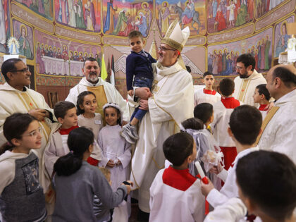 Latin Patriarch of Jerusalem Pierbattista Pizzaballa (C) poses for a picture with people a