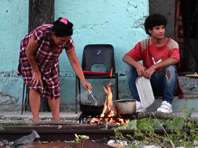 GettyImages-2204784666 Cubans cook outside their home during a nationwide blackout caused by a power grid failure