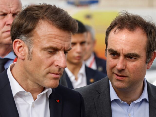 French President Emmanuel Macron (L) walks alongside Minister of Armed Forces Sebastien Le