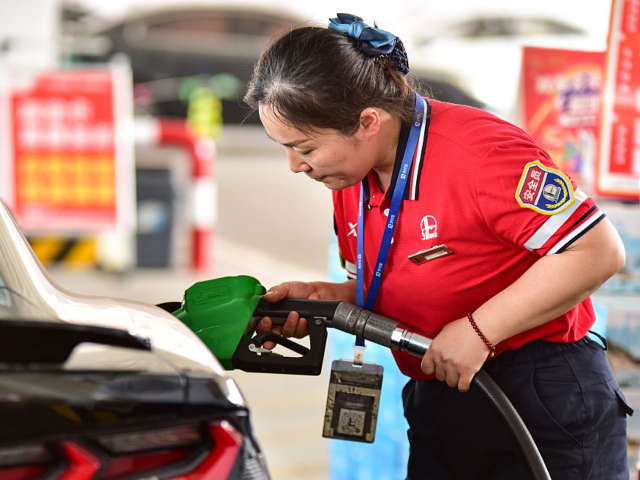 FUYANG, CHINA - MAY 19, 2025 - A staff member is refueling a car at a gas station in Fuyan