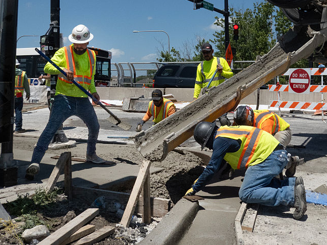 GettyImages-2221775604 CHICAGO, ILLINOIS - JUNE 23: Construction workers finish concrete as temperatures climbed