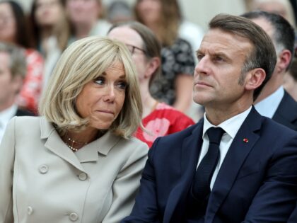 TOPSHOT - France's President Emmanuel Macron and his wife Brigitte Macron attend a ceremon